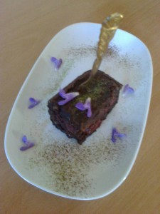 Torti mit Schokoladenglasur verziert mit Salbeiblüten